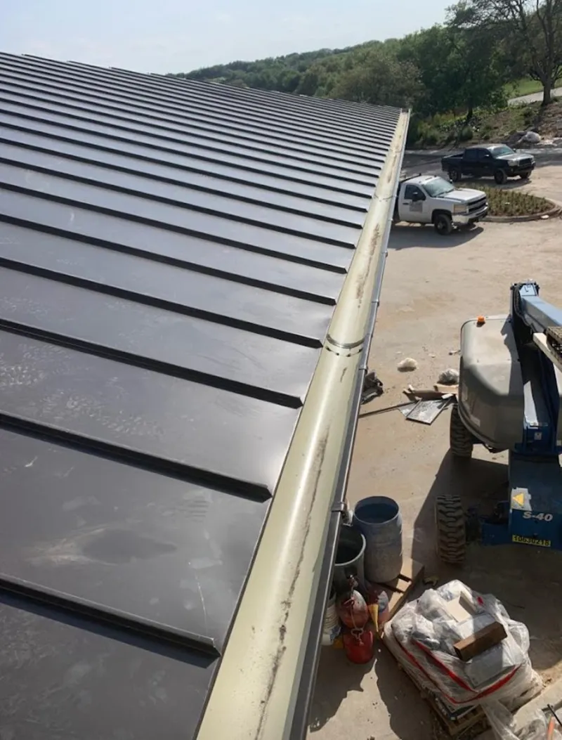 Standing seam panel and gutter detail on a metal roofing jobsite in Tolland